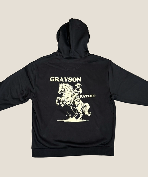 Black hoodie with a horse and rider graphic and text on the back against a beige background
